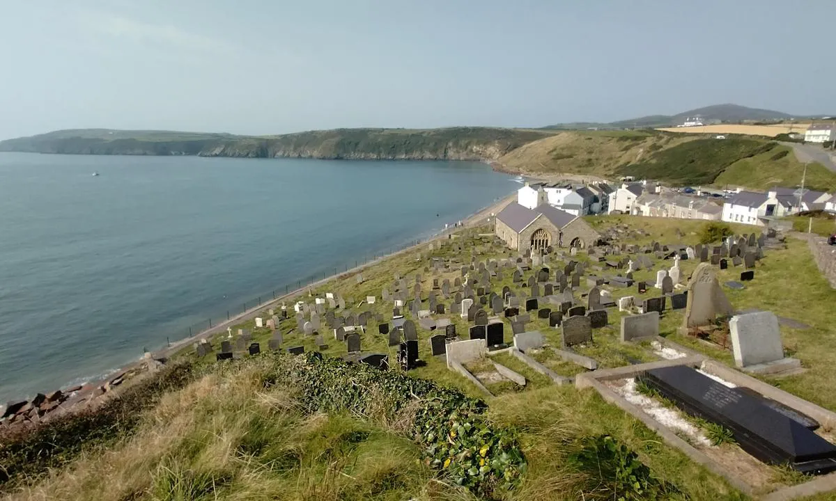 Aberdaron Beach: {"base": "en", "no": "Med utsikt over bukten fra NE, bak kirkeg\u00e5rden.", "se": "Med utsikt \u00f6ver bukten fr\u00e5n NE, bakom kyrkog\u00e5rden.", "en": "Overlooking the bay from NE, behind the cemetary.", "da": "Med udsigt over bugten fra NE, bag kirkeg\u00e5rden."}