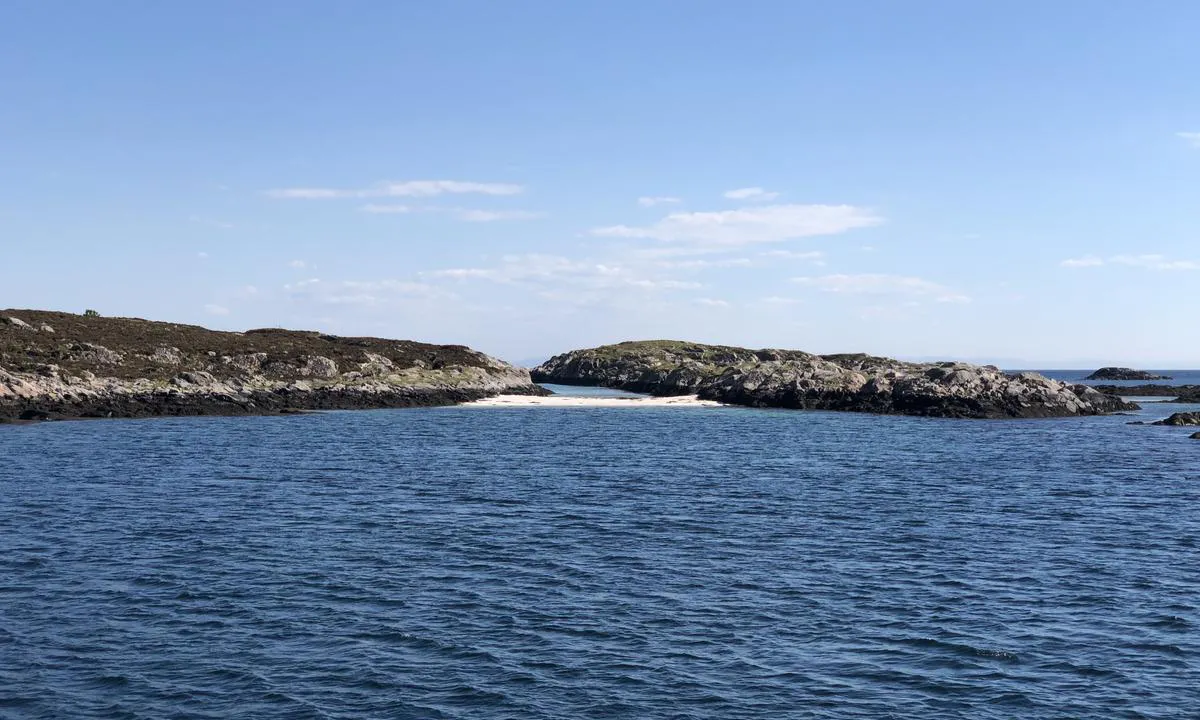 Innerst i bukta ved ankringsplassen på Litle Risøya er det en liten sandstrand, som muligens kun er tilgjengelig på fjære sjø.