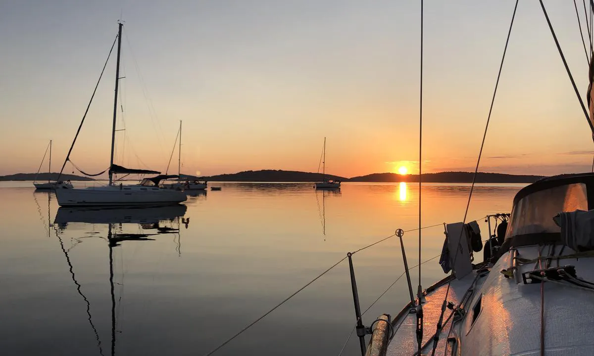 Soloppgang på anker ved Sandøbukta. Dette er en populær ankringsplass om sommeren, og det kan ligge titalls båter på svai her gjennom rolige netter hvor man kan legge seg lenger ut (der er man utsatt om det blåser mer).