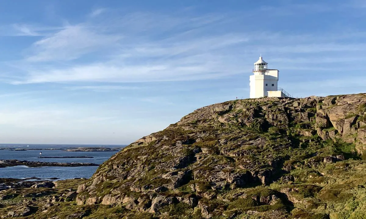 Sula Fyr står majestetisk på nordsiden av en kolle. Du ser kollen og fyret i god tid før du kommer til Sula.