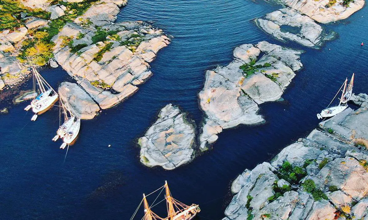 Svenska Högarna - SXK Stockholm bouy: bottom right corner main lighthouse island. top left corner island with naturreservat. only stepping on rocks allowed where the four boats are docked. betrween the old wooden boat and four boats there is a shallow visible in the picture. between the two groups of the two boats there is also a shallow underneath the rock to dock on!!